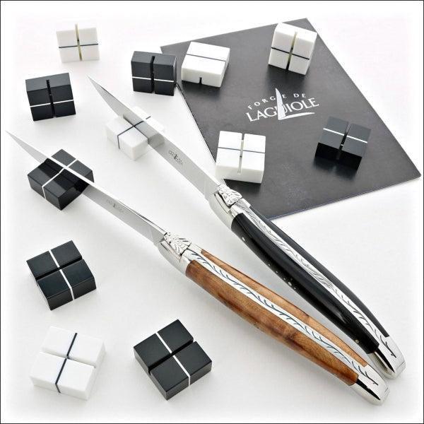table knife rests black and with with laguiole steak knives in the foreground 