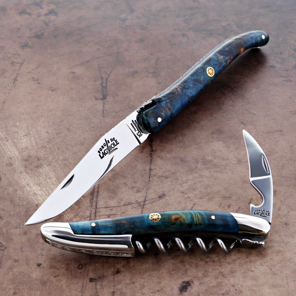 Foldable knife and corkscrew with blue handle on a textured surface