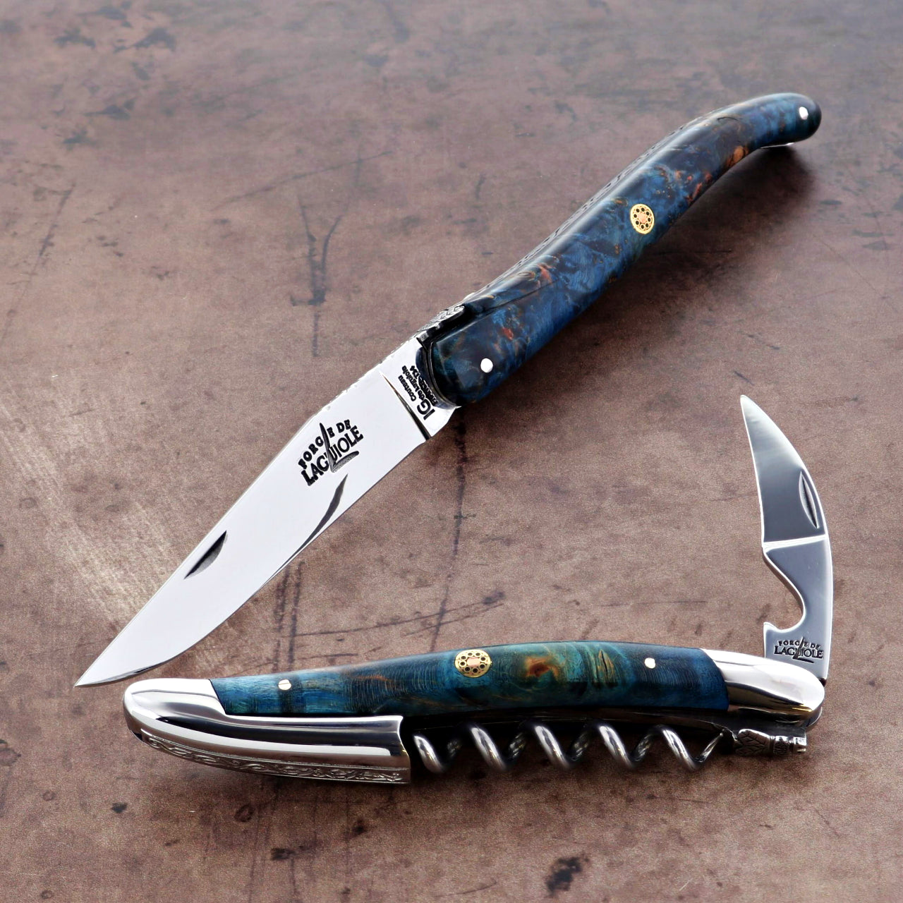 Foldable knife and corkscrew with blue handle on a textured surface