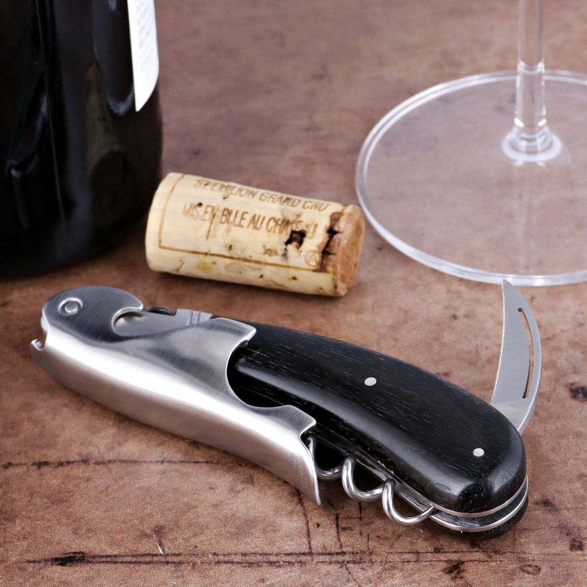 Laguiole Magnum Ebony Corkscrew, close-up side view, black ebony handle, stainless steel, wine bottle, cork.