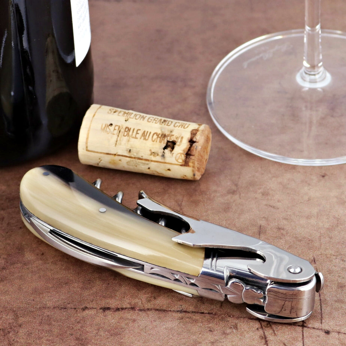 Laguiole Magnum Flamed Horn Tip Corkscrew, close-up of horn handle, stainless steel, with wine cork.