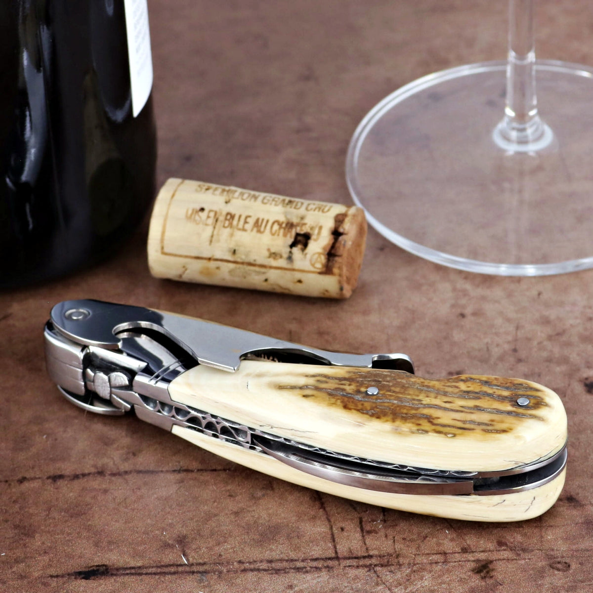 Laguiole Magnum Guilloche corkscrew, fossilized mammoth ivory handle, close-up.