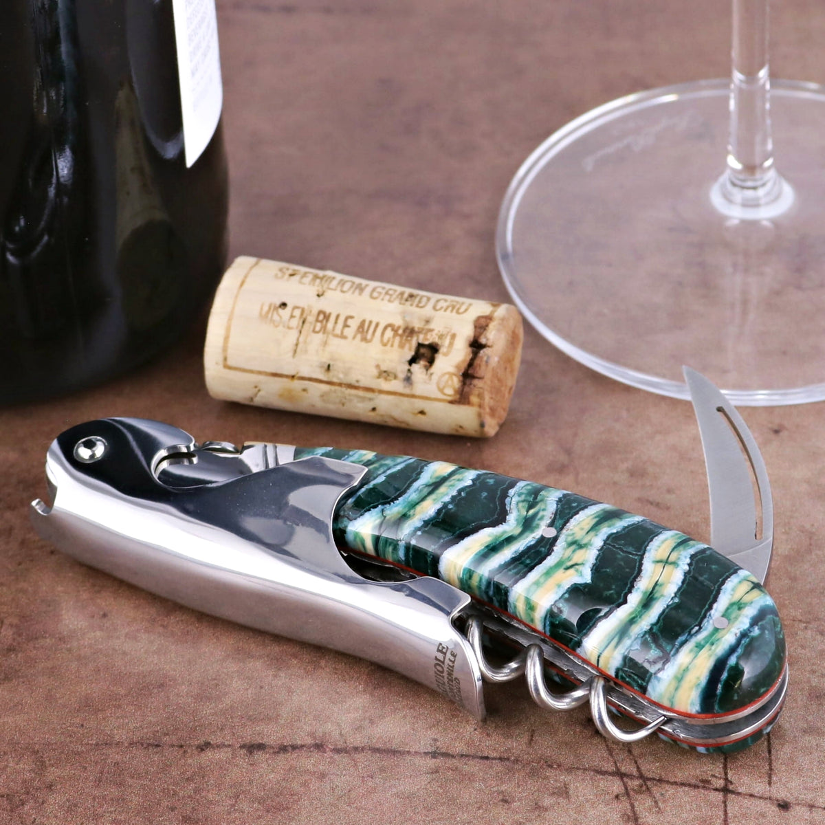 Laguiole Magnum Guilloche Mammoth Tooth - Rain Forest corkscrew, close-up of green and white patterned handle.