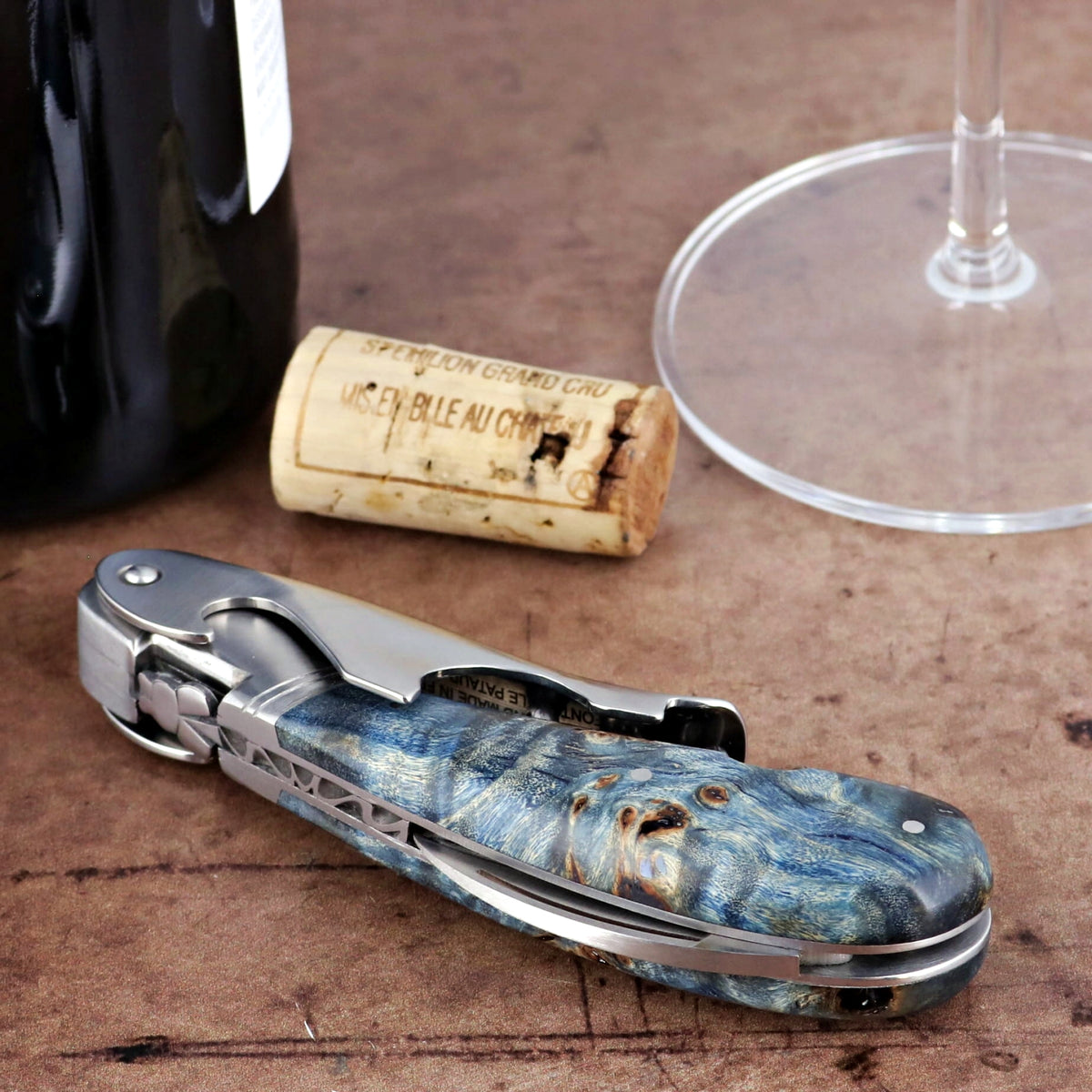 Laguiole Magnum Stained Poplar Burl Corkscrew Blue, close-up of blue burl handle and polished metal.