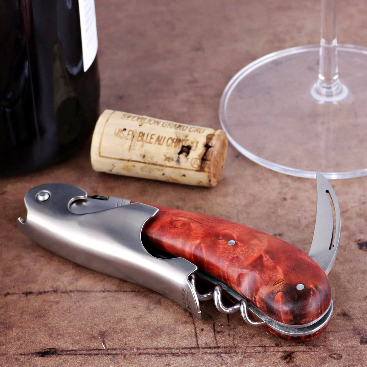 Laguiole Magnum Stained Poplar Burl Corkscrew Red - E, close-up of the red wood handle and metal tools.