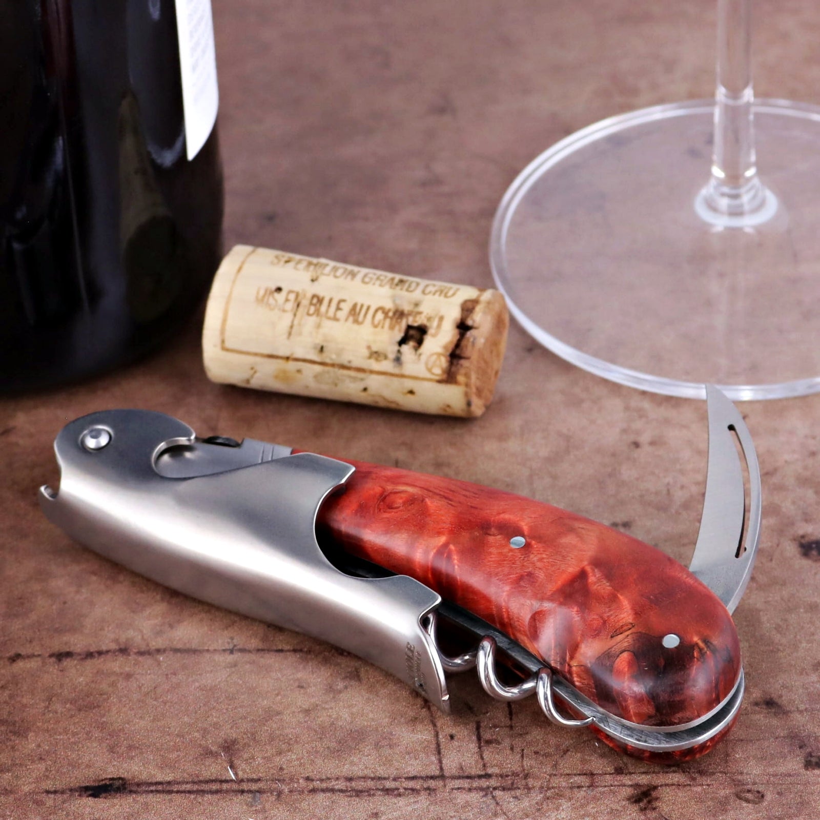 Laguiole Magnum Stained Poplar Burl Corkscrew Red - E, close-up of the red wood handle and metal tools.