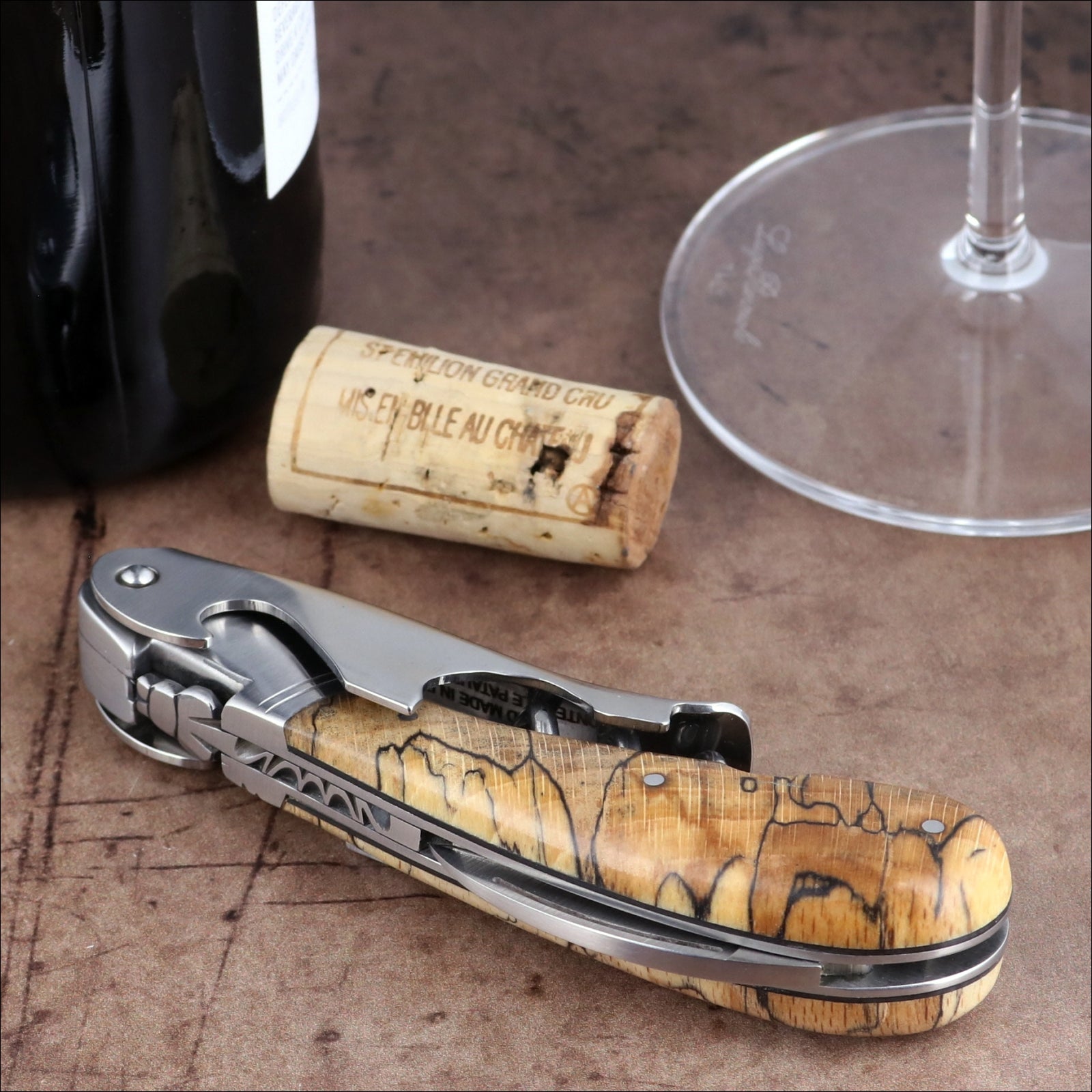 Laguiole Magnum Burled Beech Corkscrew, close-up of polished steel and natural wood handle detail.