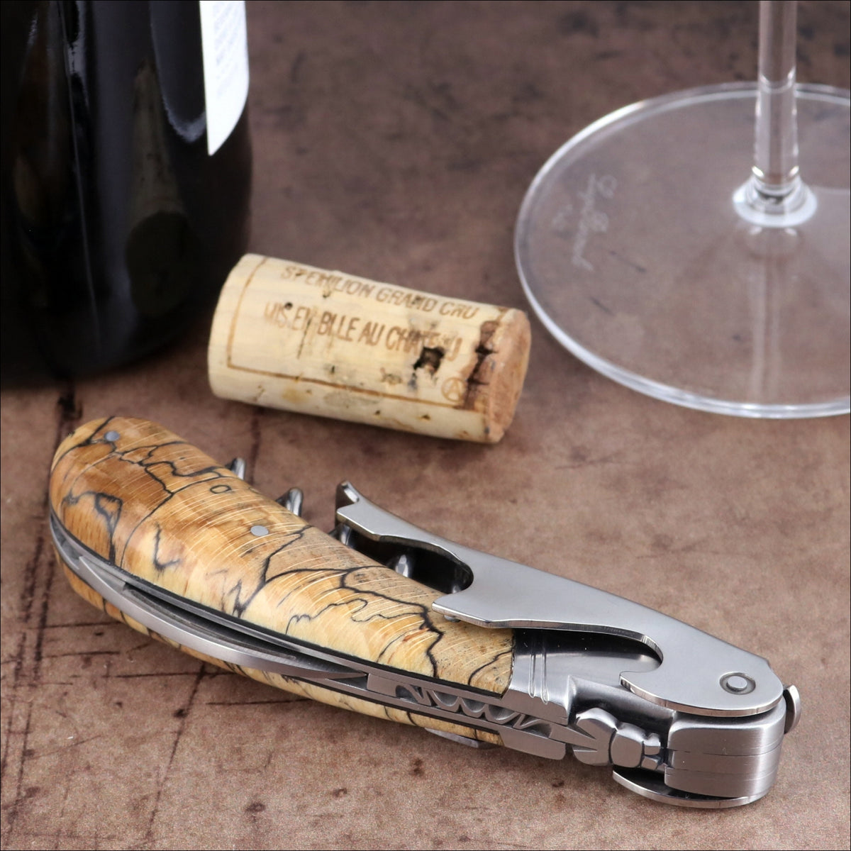 Laguiole Magnum Burled Beech corkscrew, high-angle view of wood handle and stainless steel tool.