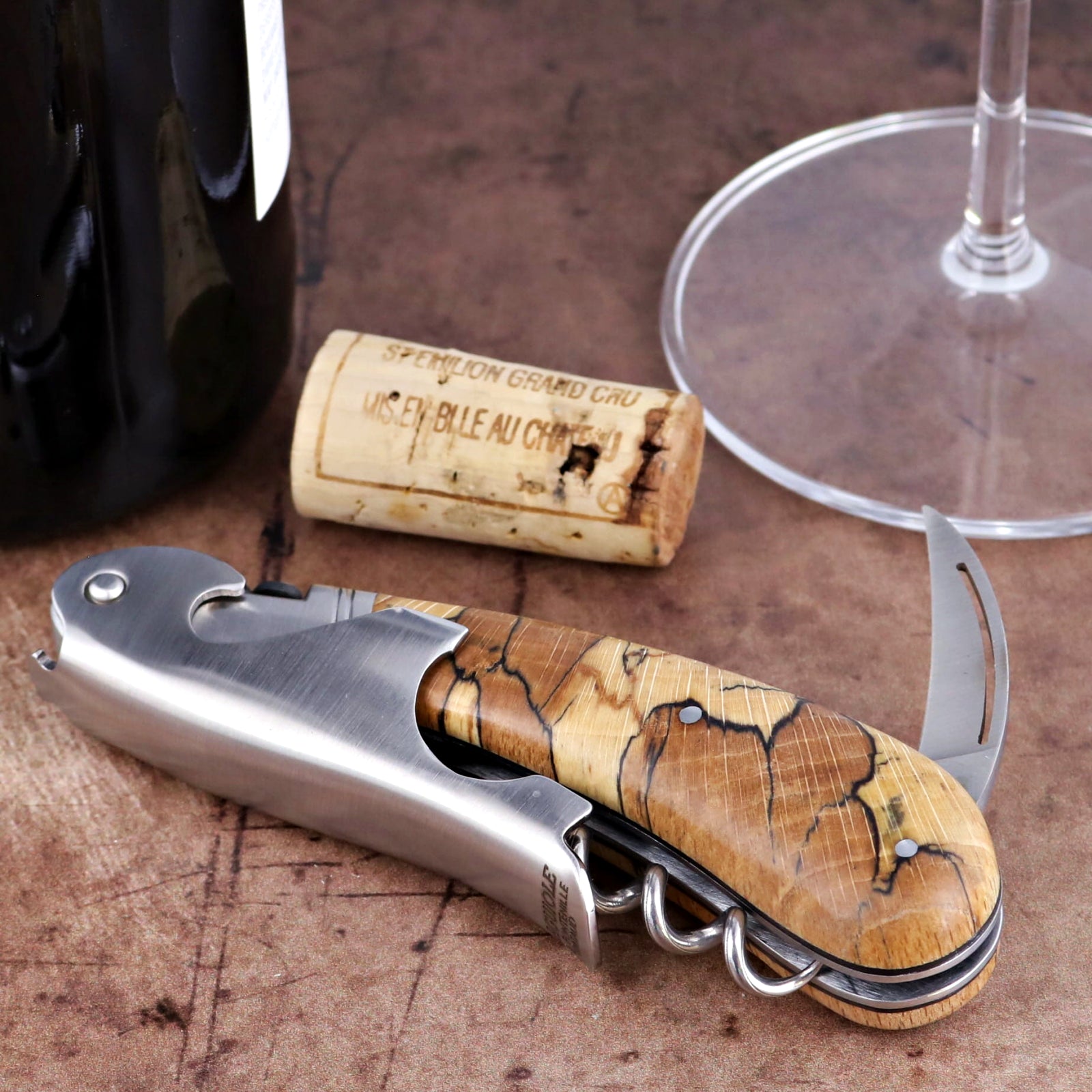 Laguiole Magnum Burled Beech Corkscrew, close-up of stainless steel and wood handle with wine cork.