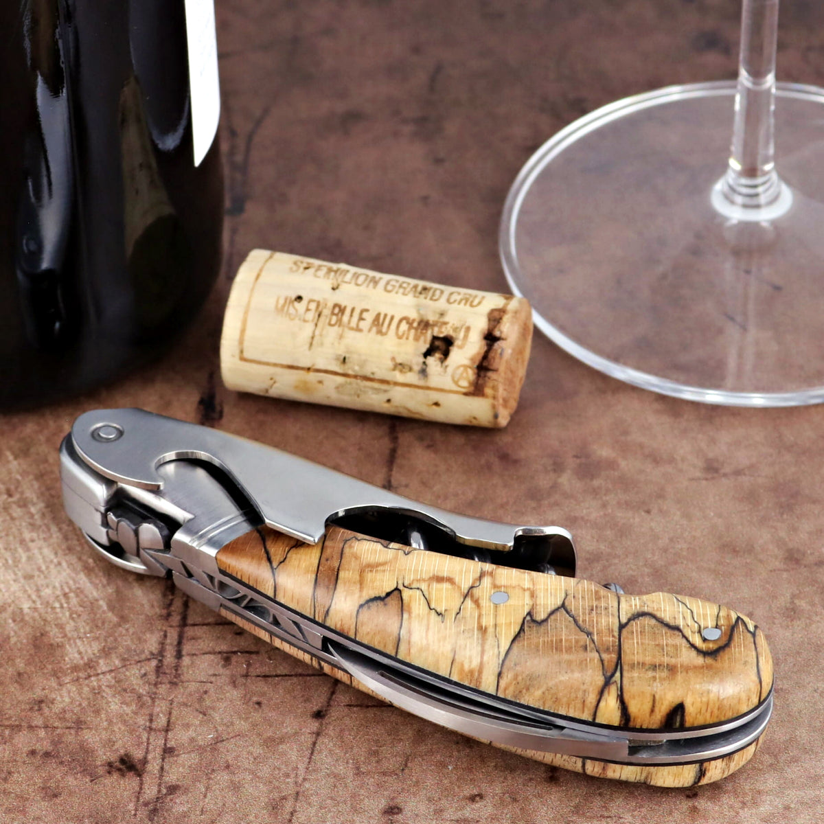 Laguiole Magnum Burled Beech corkscrew, close-up side view showing polished steel and wood grain handle.