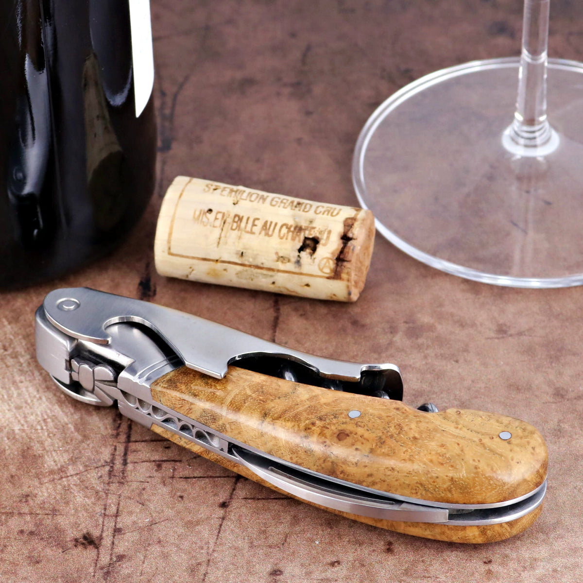 Laguiole Magnum Burled Maple Corkscrew close-up showing polished steel and wood grain handle detail.