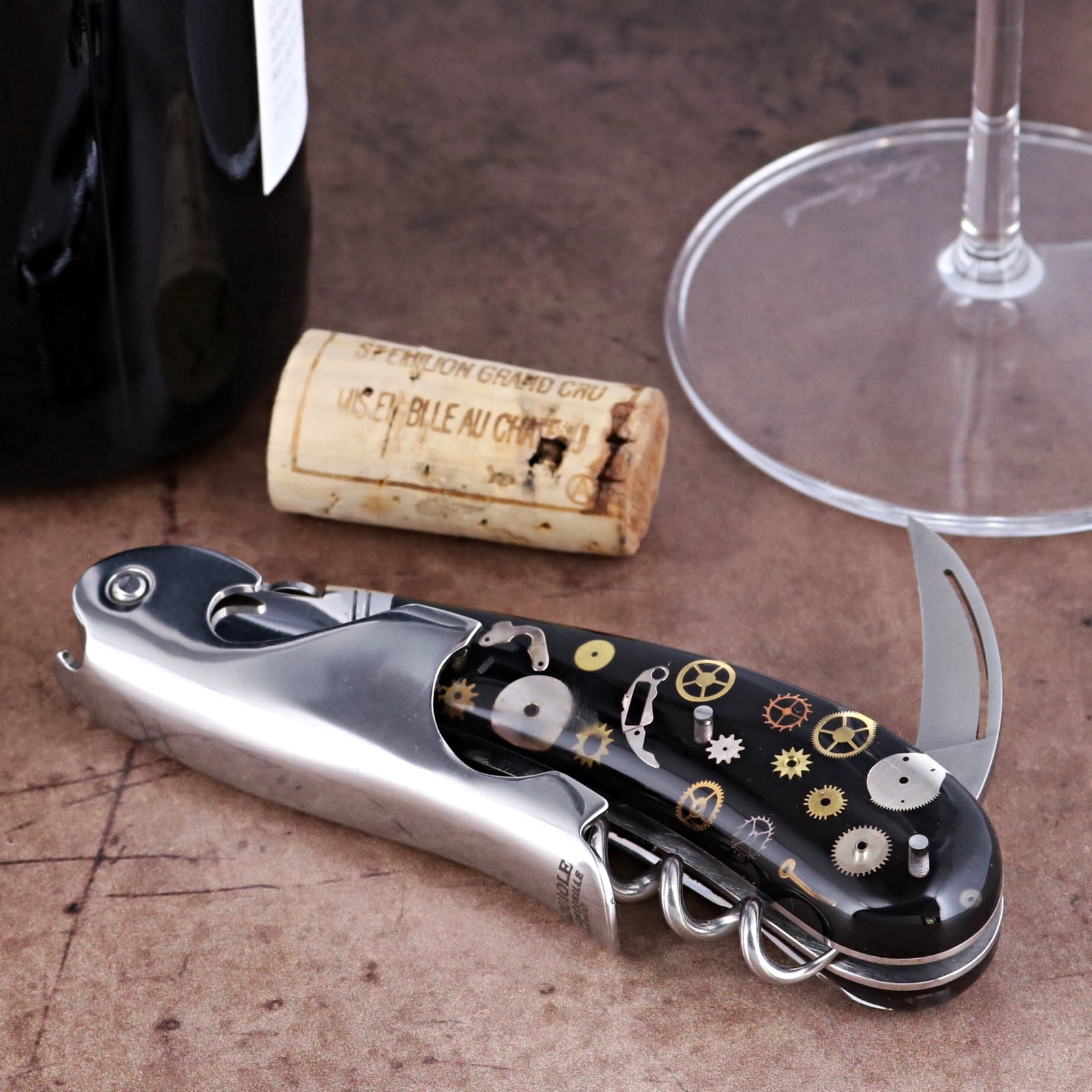 Laguiole Magnum Corkscrew close-up showing black handle with intricate gold and silver gear inlays.
