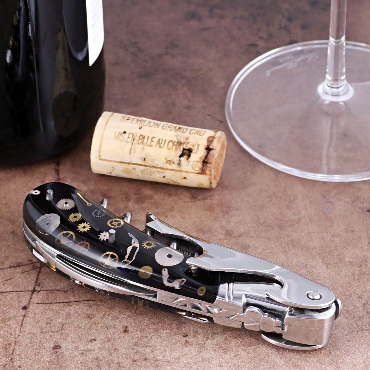 Laguiole Magnum Corkscrew close-up showing a black handle with intricate gold timepiece gear inlays.