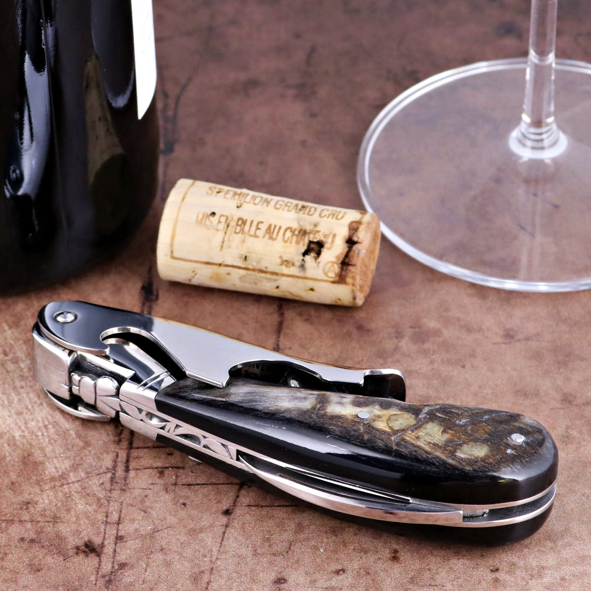 Laguiole Magnum Dark Ram Horn Corkscrew, close-up side view of polished horn handle and steel frame.