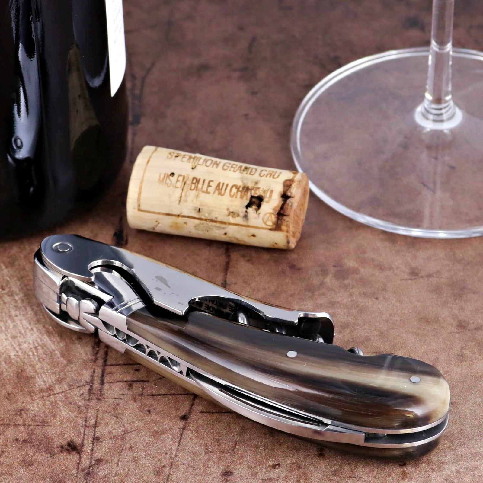 Laguiole Magnum Flamed Horn Tip corkscrew, close-up side view showing polished steel and horn handle.