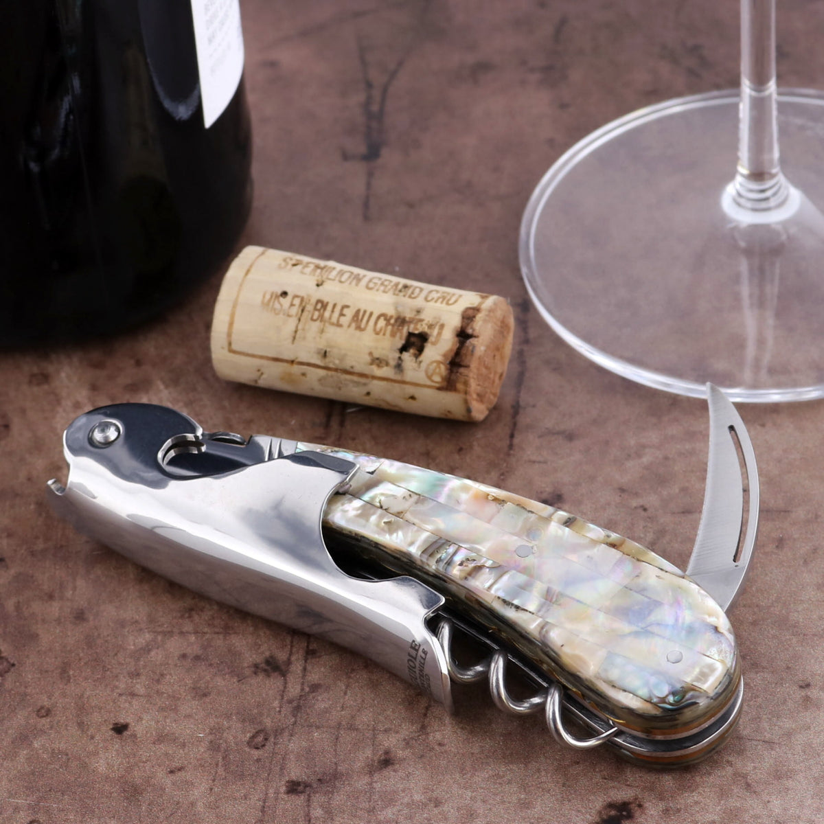 Laguiole Magnum Genuine Mother of Pearl Guilloche Corkscrew, close-up of iridescent handle and polished steel.