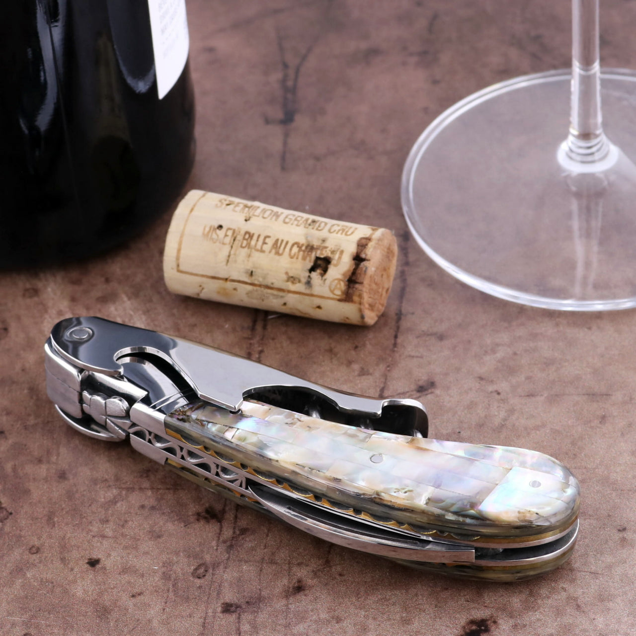 Laguiole Magnum Genuine Mother of Pearl Guilloche Corkscrew, close-up of iridescent handle and polished steel.
