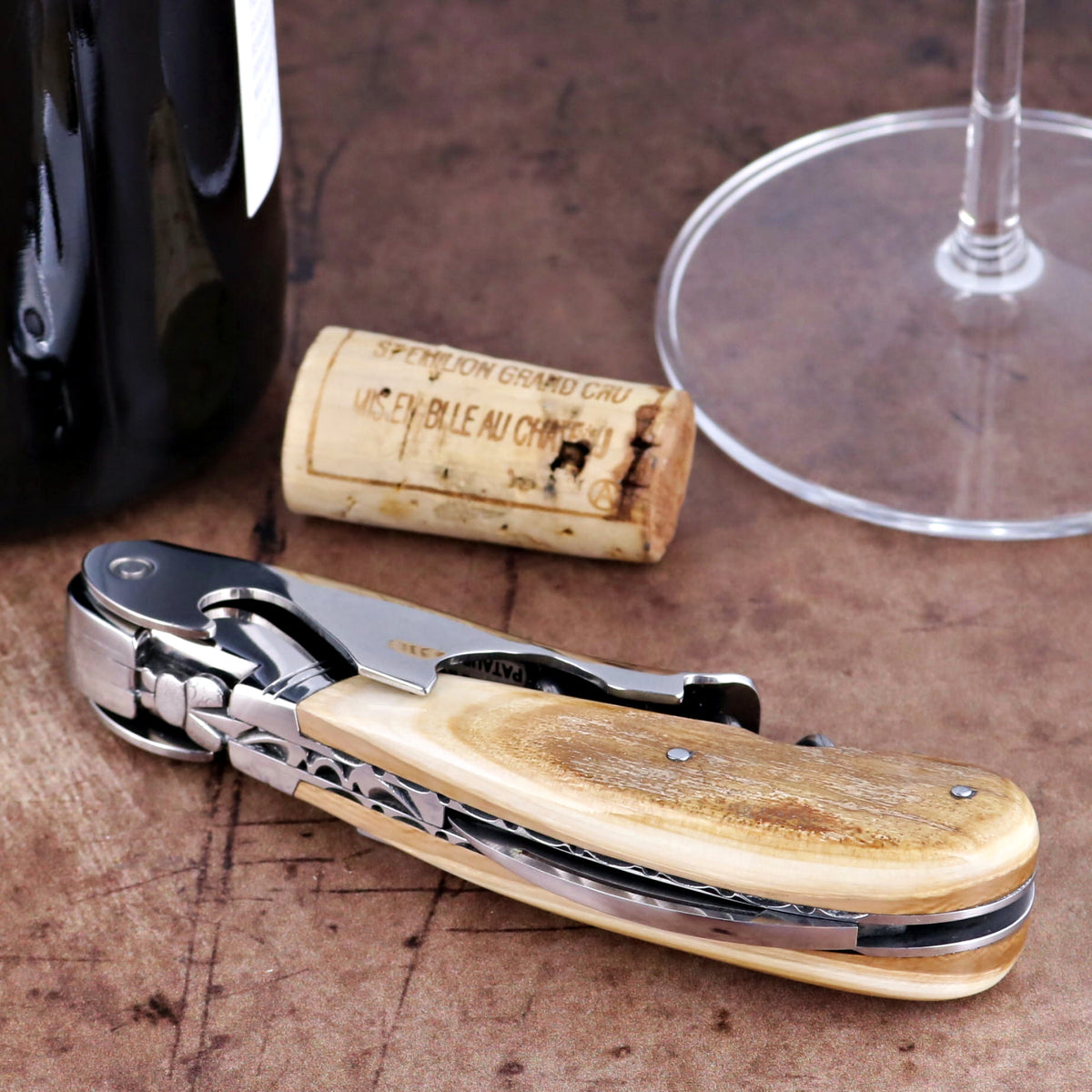Laguiole Magnum Guilloche corkscrew, close-up of cream fossilized mammoth ivory handle and steel detail.