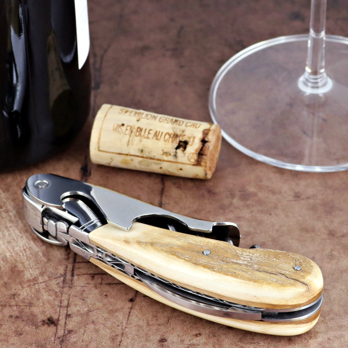 Laguiole Magnum Guilloche corkscrew, close-up of cream fossilized mammoth ivory handle and steel.