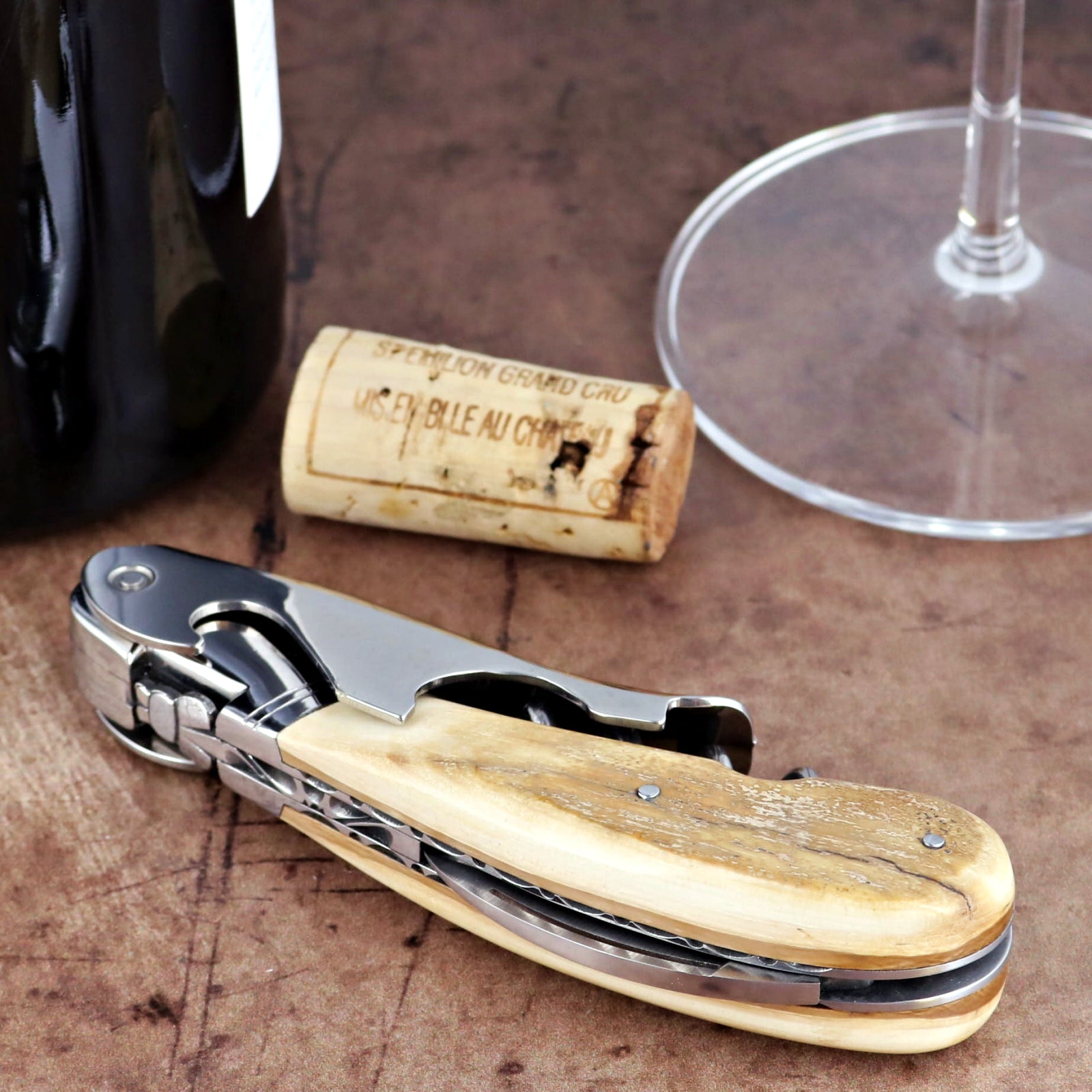 Laguiole Magnum Guilloche corkscrew, close-up of fossilized mammoth ivory handle and steel mechanism.