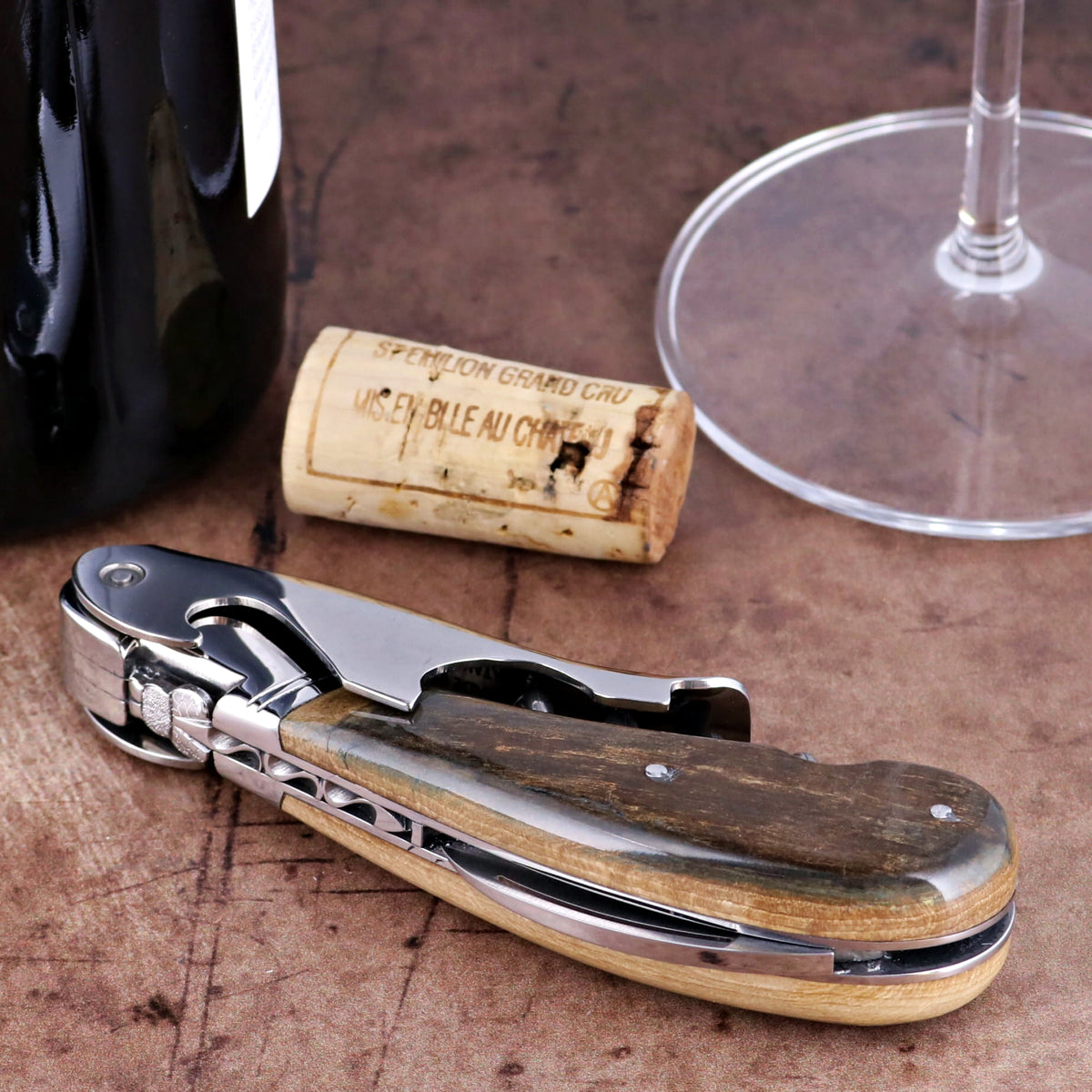 Laguiole Magnum Fossilized Mammoth Ivory Corkscrew, close-up of brown textured handle and steel frame.
