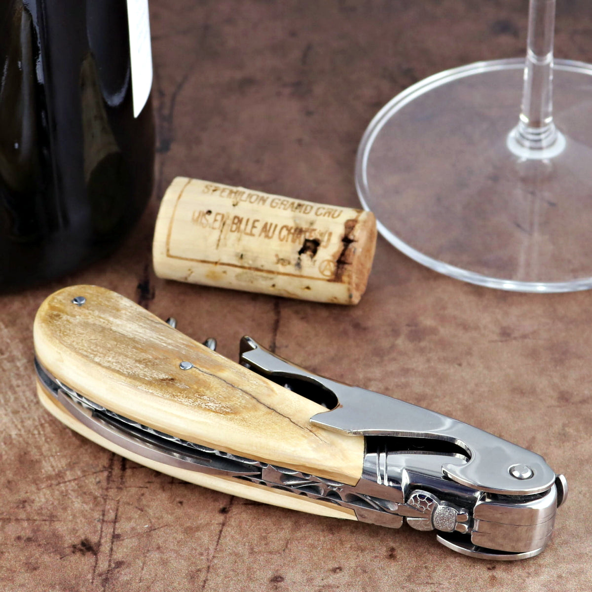 Laguiole Magnum Guilloche Fossilized Mammoth Ivory Corkscrew, close-up of cream handle and steel tool.