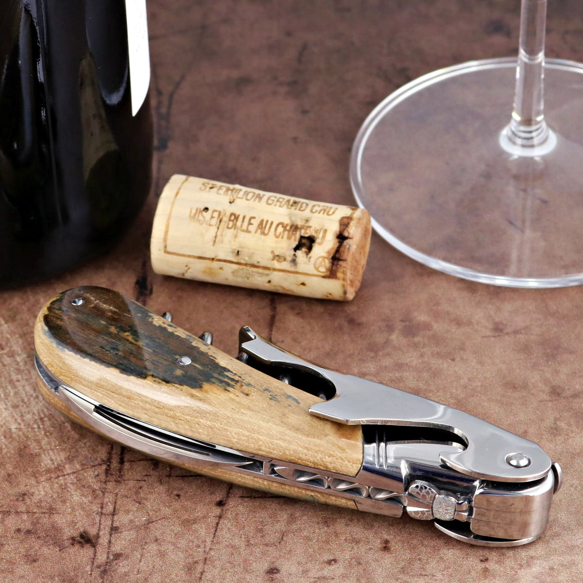 Laguiole Magnum Fossilized Mammoth Ivory Corkscrew, close-up of polished ivory handle and steel tool.
