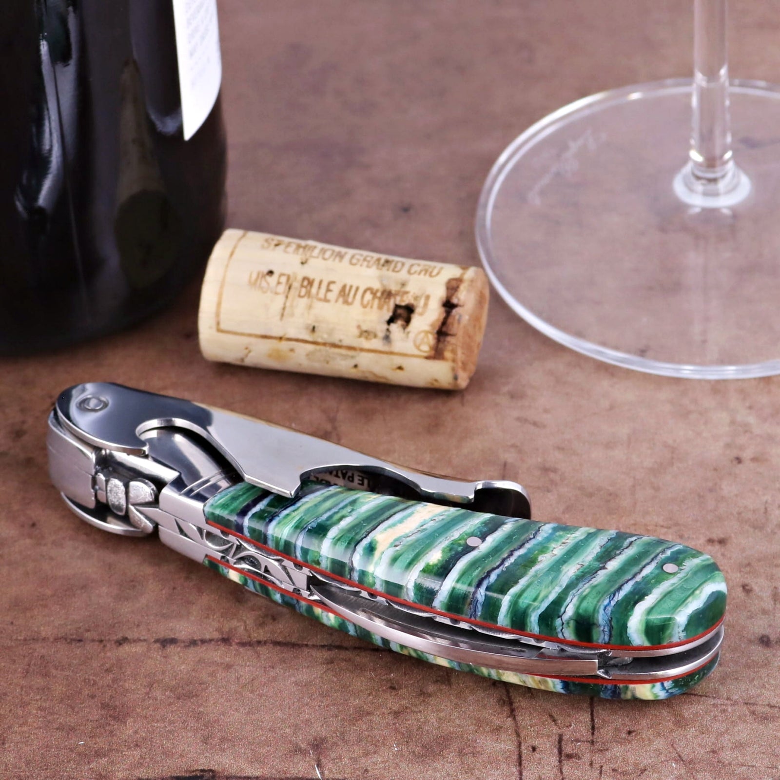 Laguiole Magnum Guilloche Mammoth Tooth - Emerald Strata corkscrew, close-up of green and white handle.