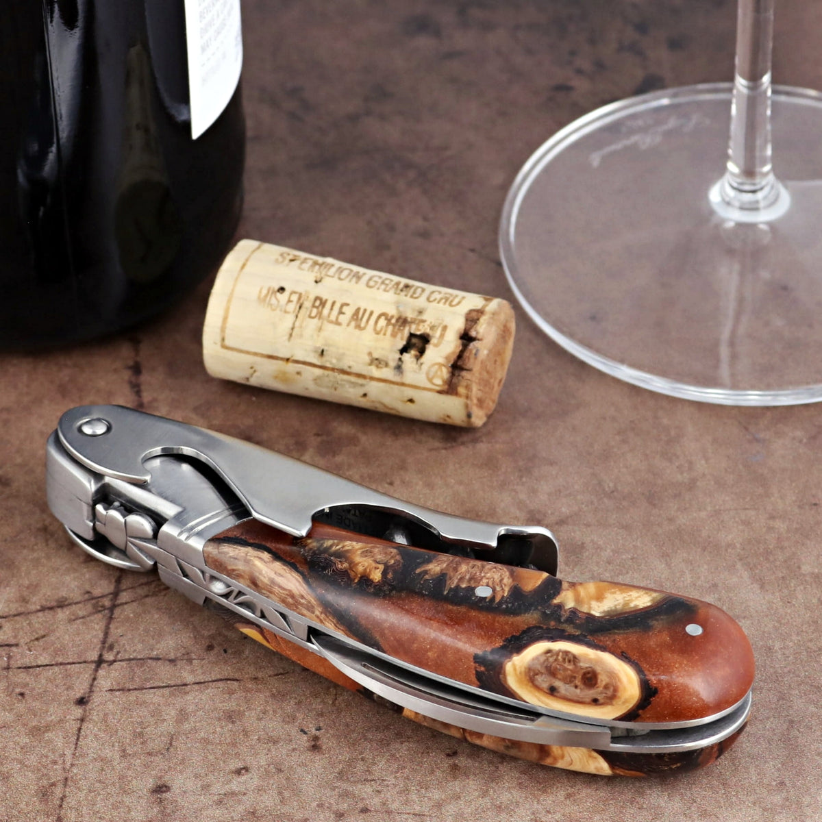 Laguiole Magnum Hybrid Juniper Burl corkscrew close-up featuring a polished steel and wood handle.