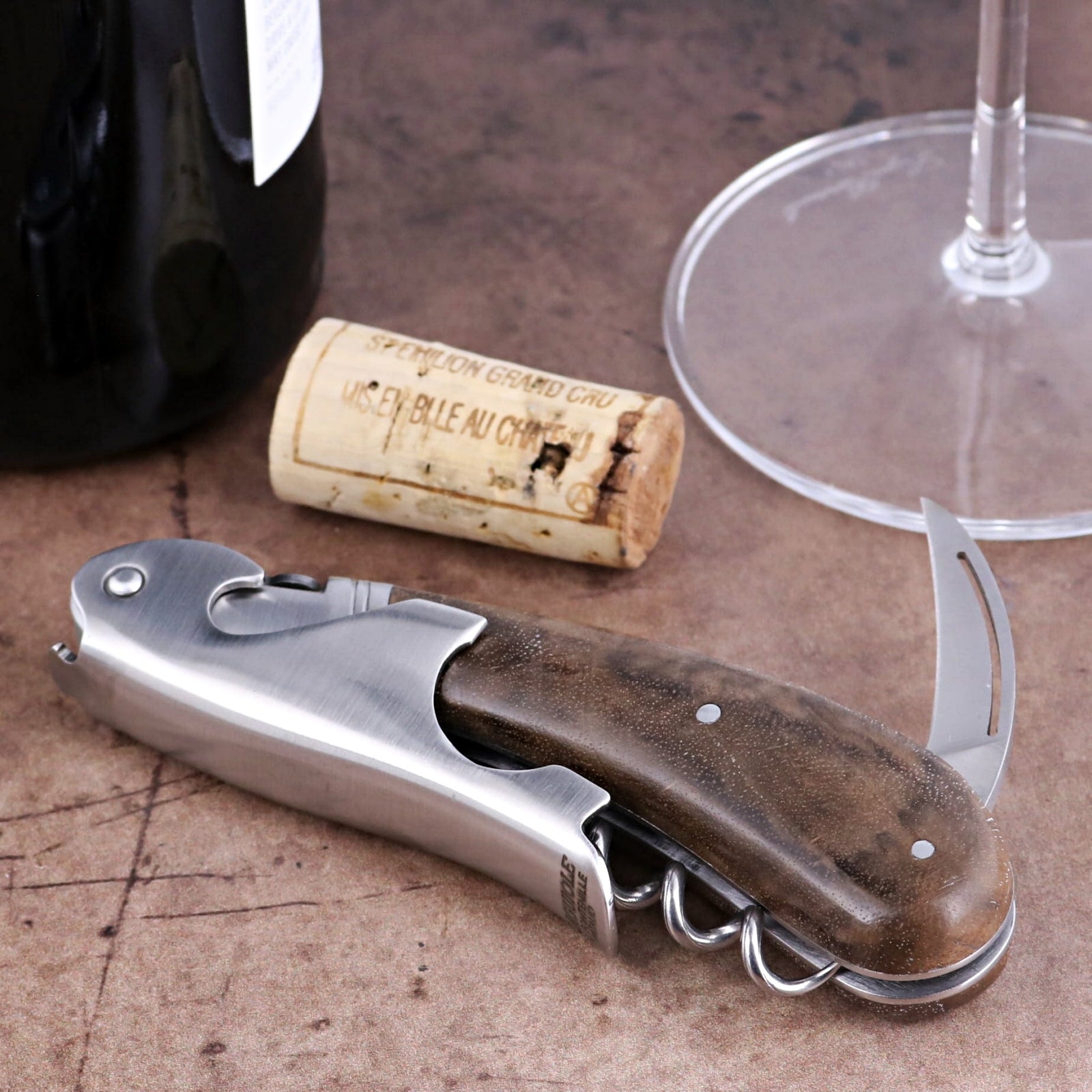 Laguiole Magnum Walnut Corkscrew, close-up of folded stainless steel tool with dark wood handle.