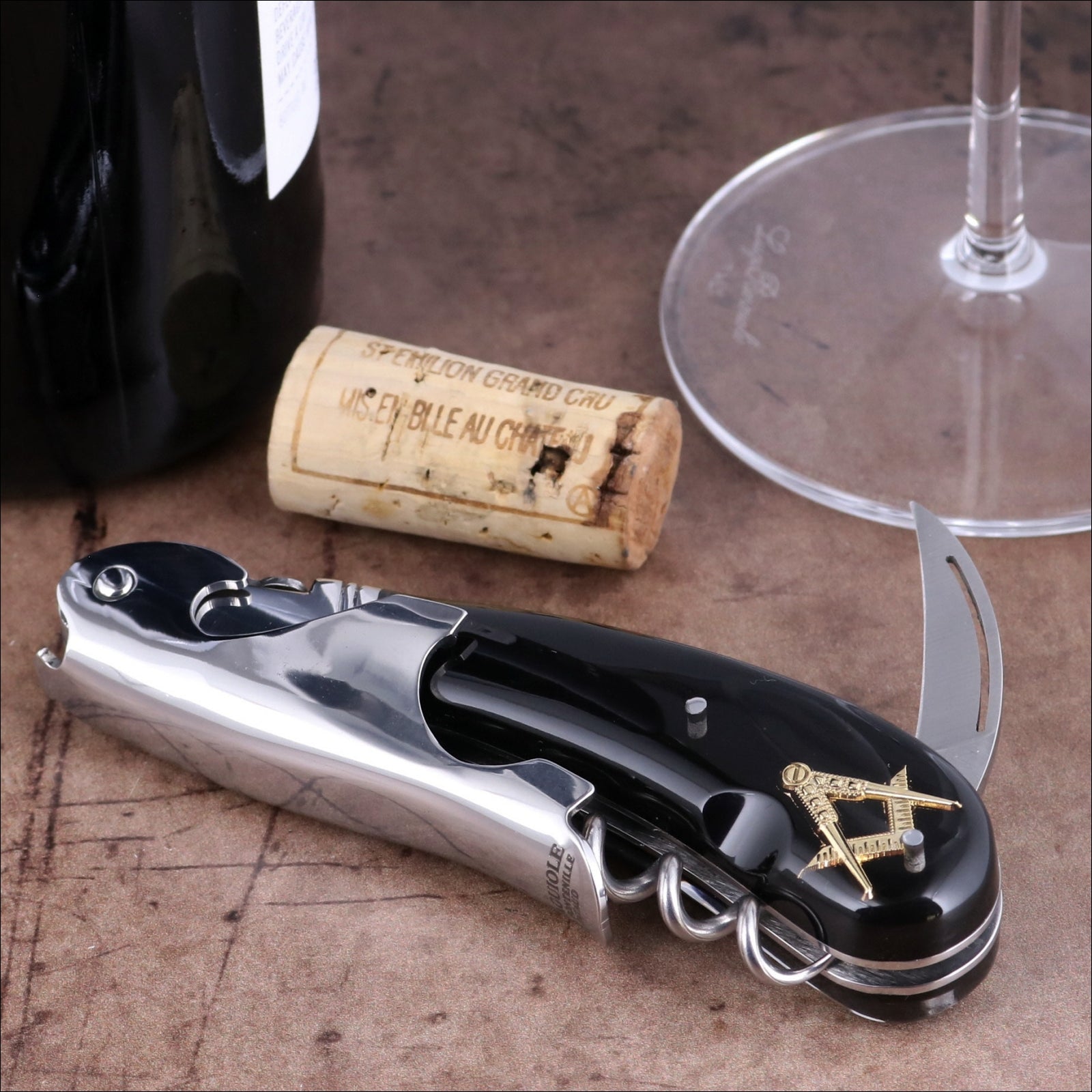 Laguiole Magnum Masonic corkscrew close-up featuring a black handle with gold square and compass inlay.