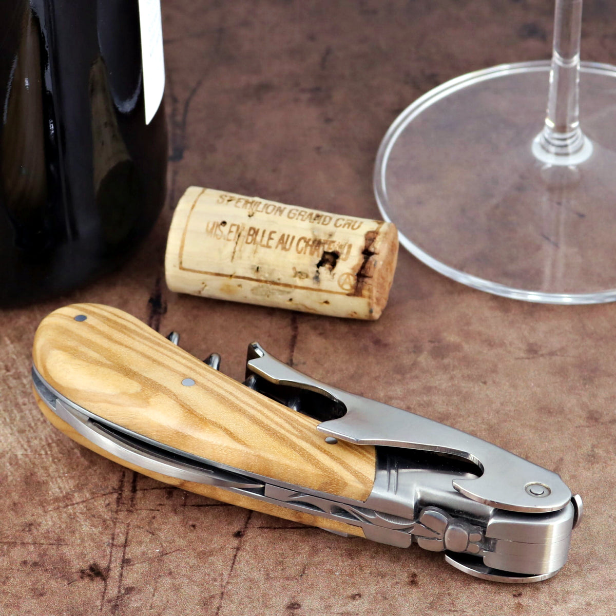 Laguiole Magnum Olive Wood Corkscrew, close-up side view showing polished steel and wood grain handle.
