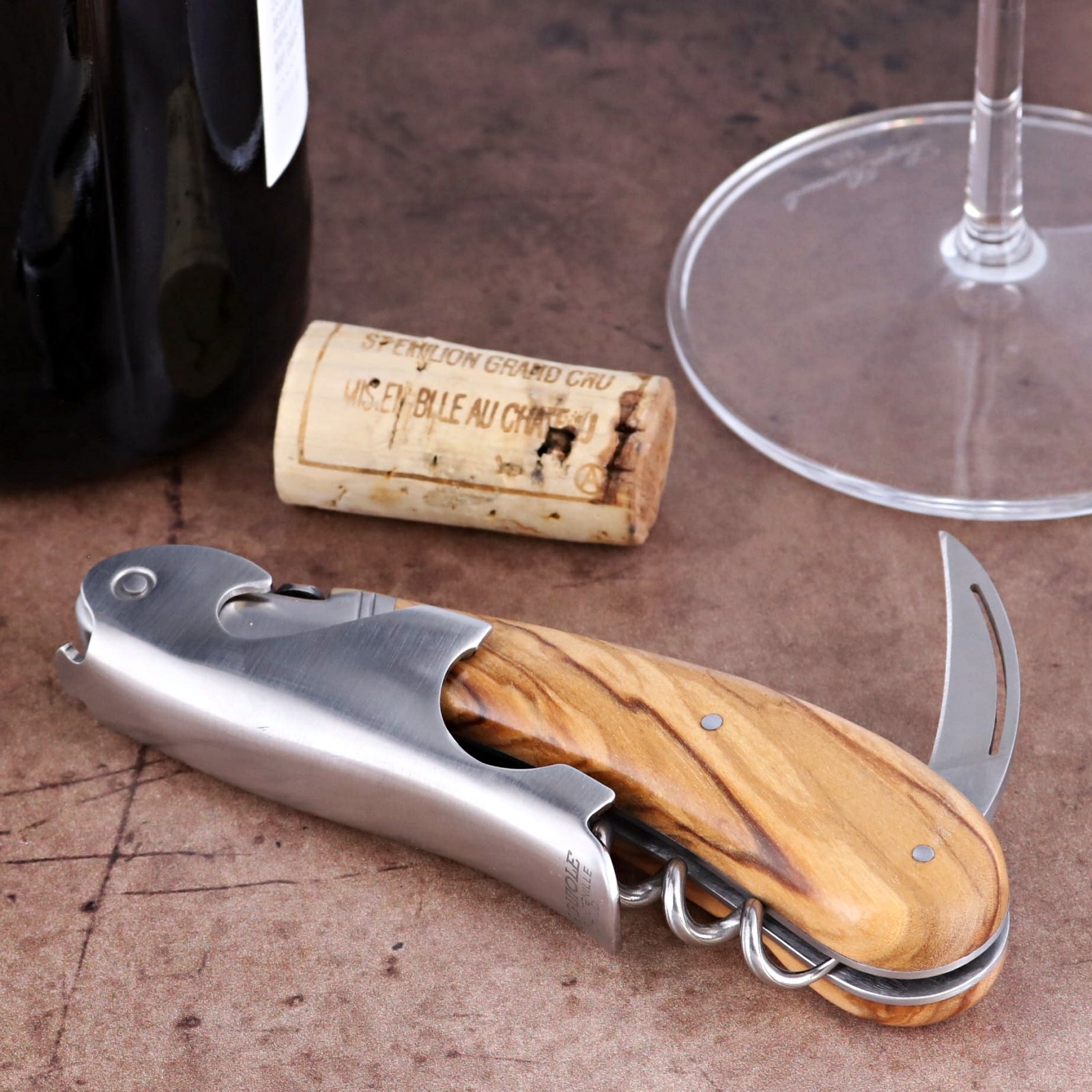 Laguiole Magnum Olive Wood Corkscrew, close-up side view showing polished steel and wood grain handle.