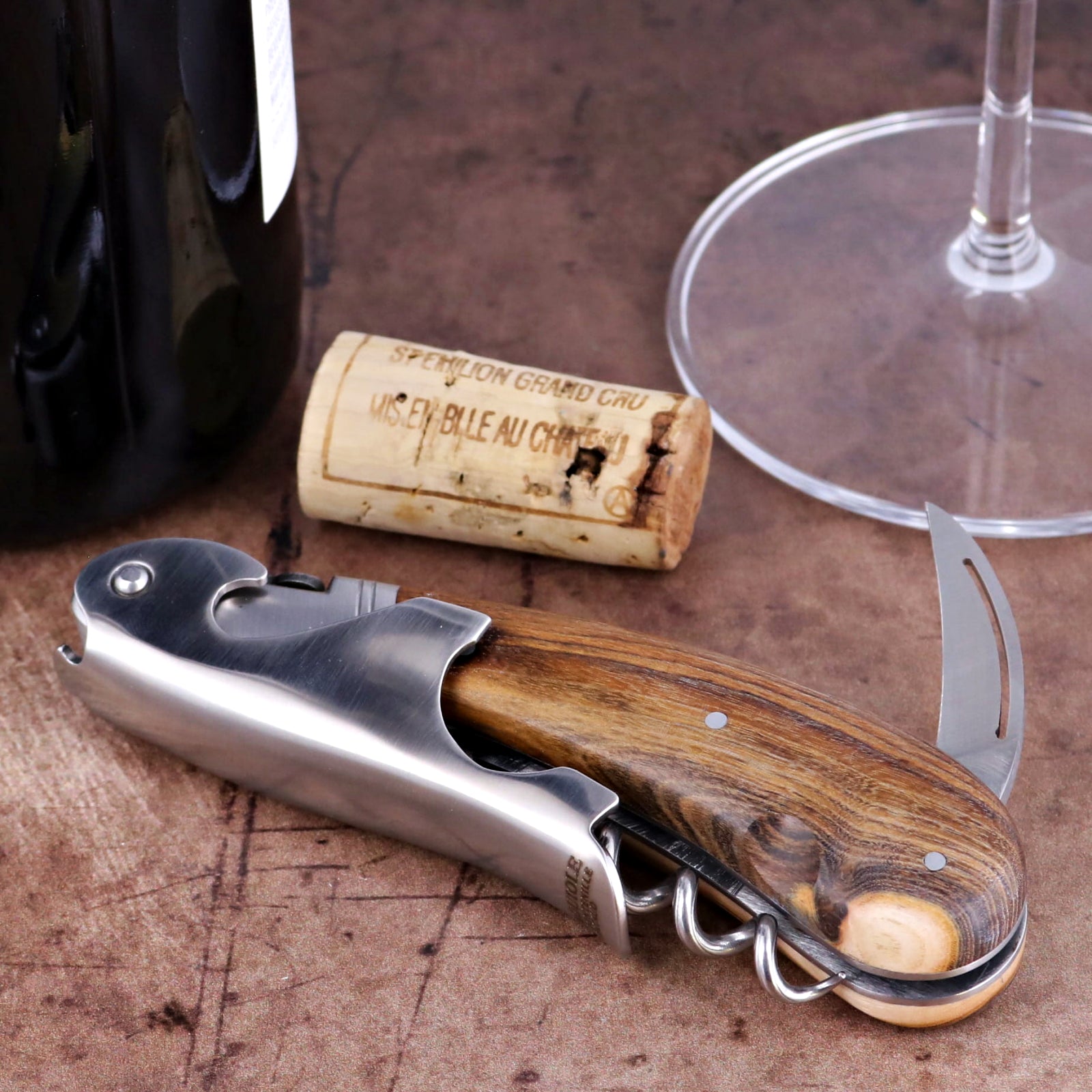 Laguiole Magnum Pistachio corkscrew close-up featuring a polished steel body and wood grain handle.