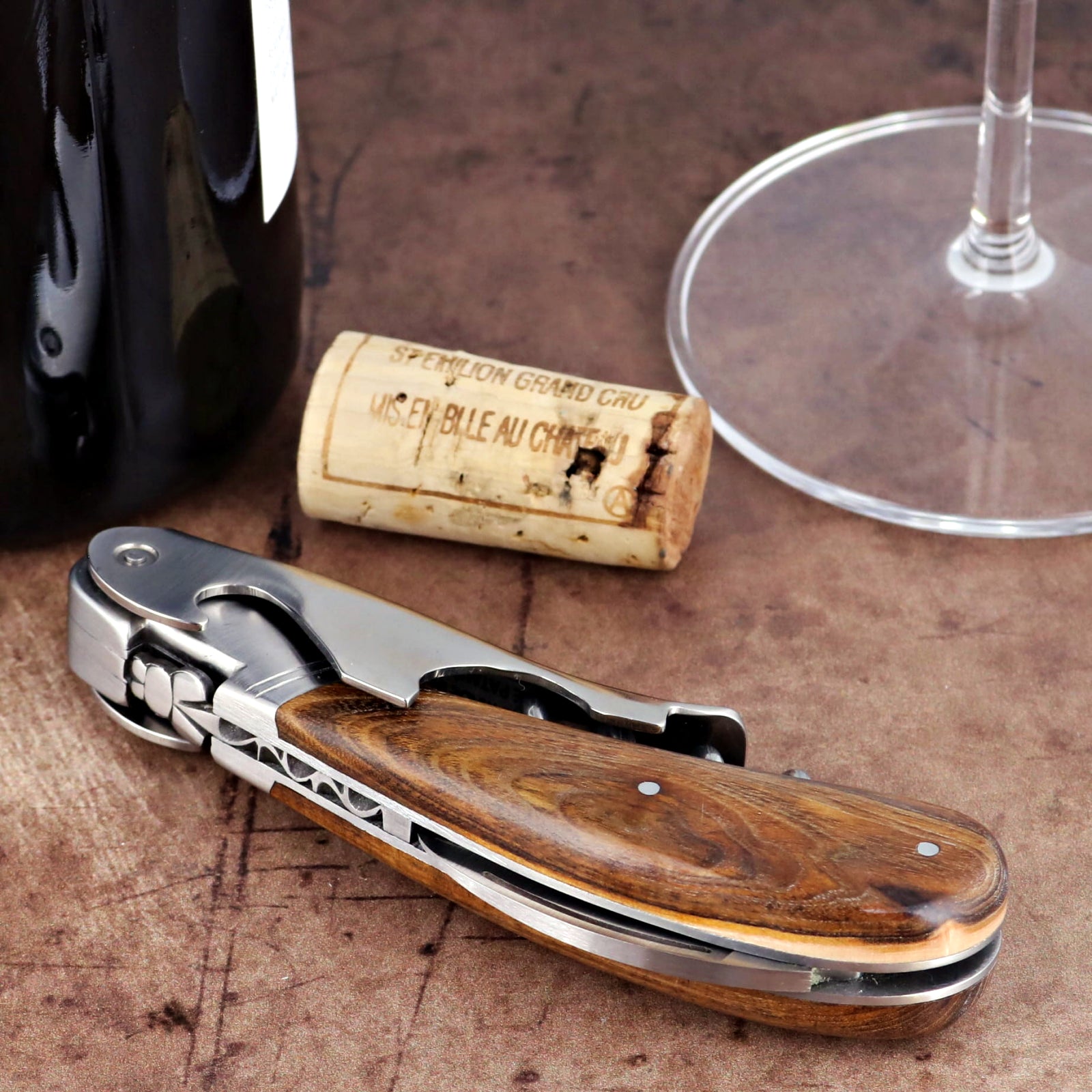 Laguiole Magnum Pistachio corkscrew close-up featuring a polished steel body and wood grain handle.