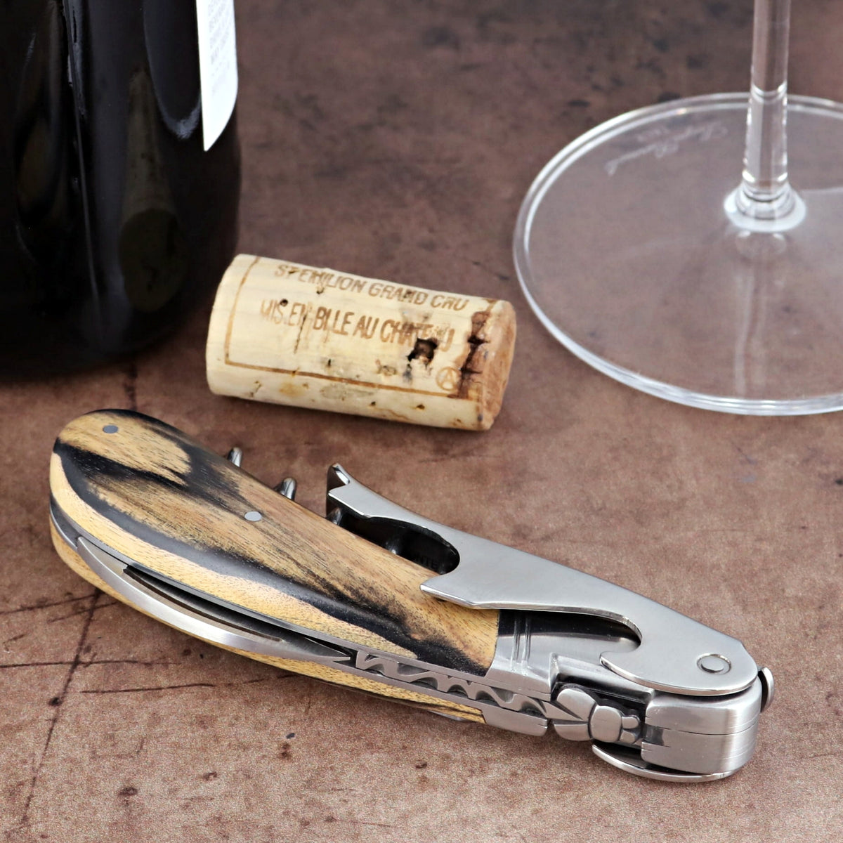 Laguiole Magnum Royal Ebony Corkscrew, close-up of folded stainless steel tool with wood grain handle.