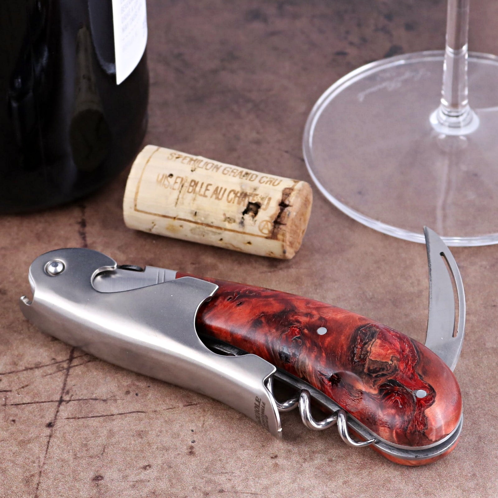 Laguiole Magnum Stained Poplar Burl Corkscrew Red, close-up of folded stainless steel and wood handle.