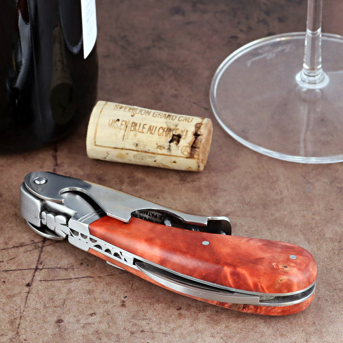 Laguiole Magnum Stained Poplar Burl Corkscrew Red, close-up of folded handle with rich wood grain.