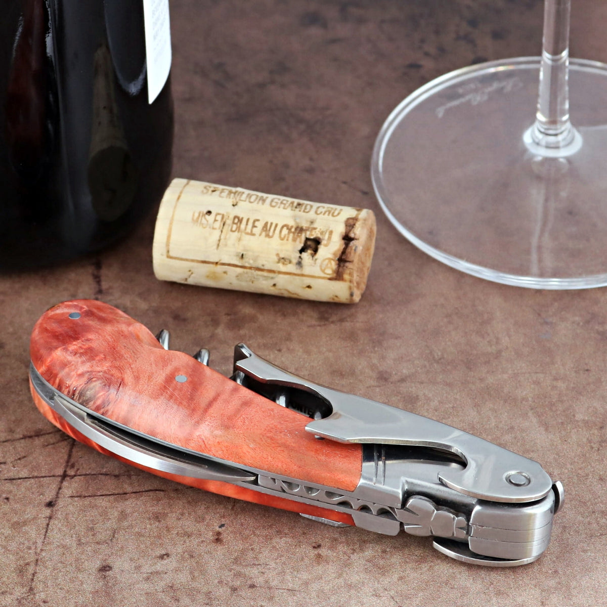 Laguiole Magnum Stained Poplar Burl Corkscrew Red, close-up of folded tool with red wood handle.
