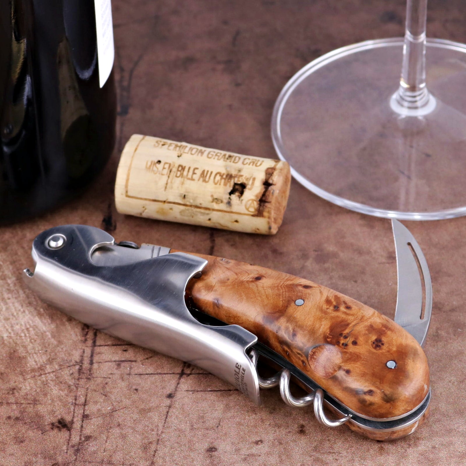 Laguiole Magnum Thuya Burl corkscrew close-up featuring a polished steel body and rich wood handle.
