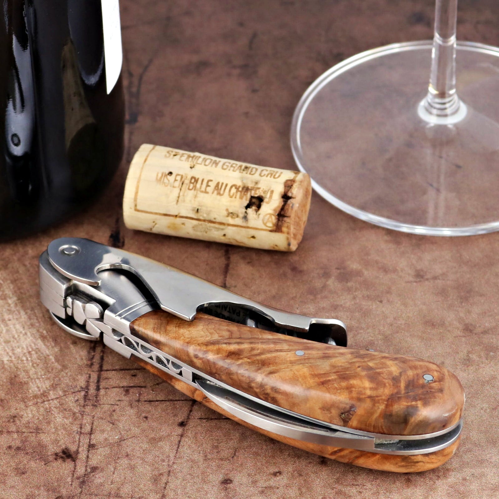 Laguiole Magnum Thuya Burl corkscrew close-up featuring a polished steel body and rich wood handle.