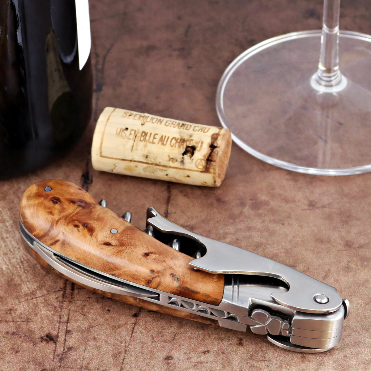 Laguiole Magnum Thuya Burl corkscrew, close-up of polished steel and natural wood handle detail.