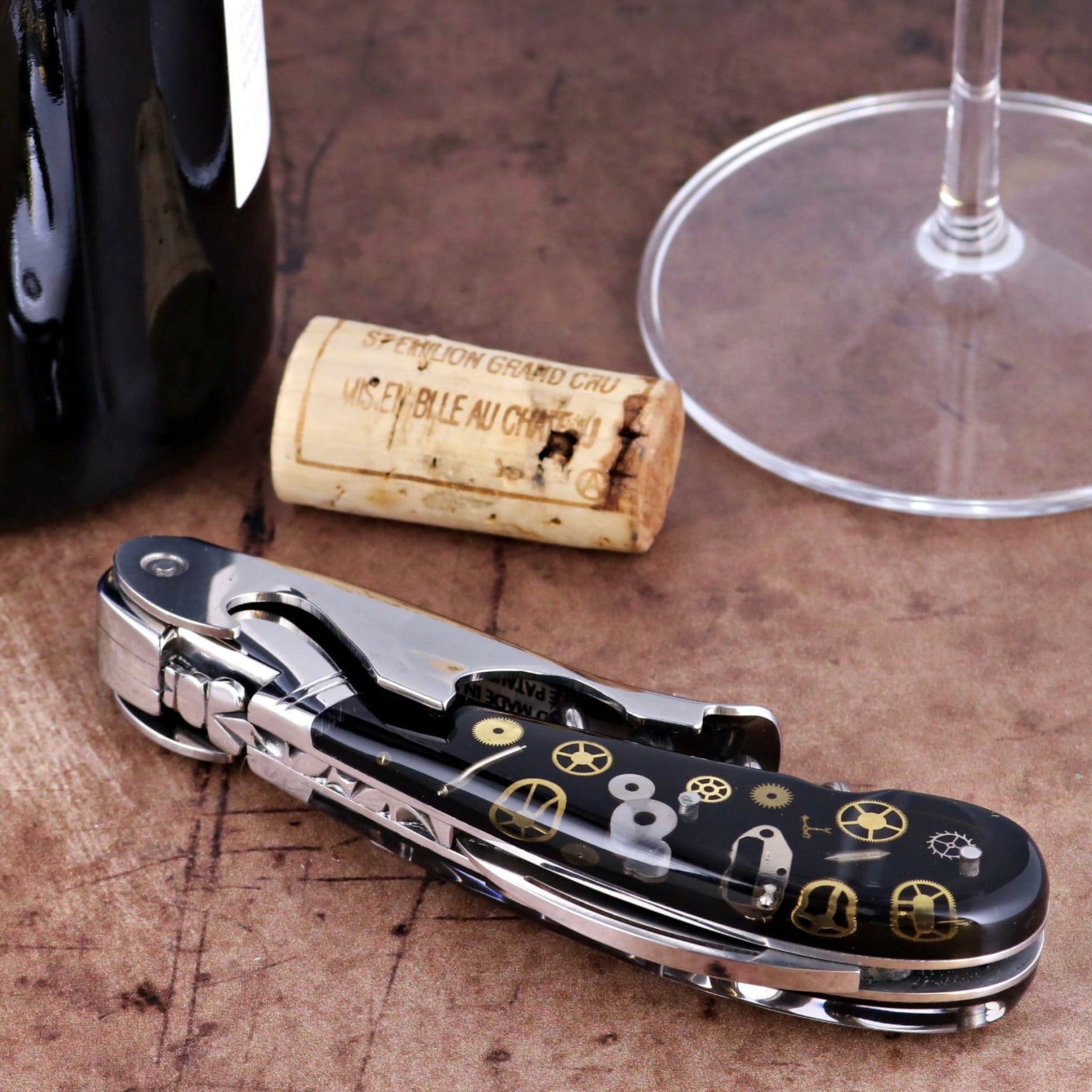 Laguiole Magnum Corkscrew close-up featuring a black handle with intricate gold timepiece gear inlays.