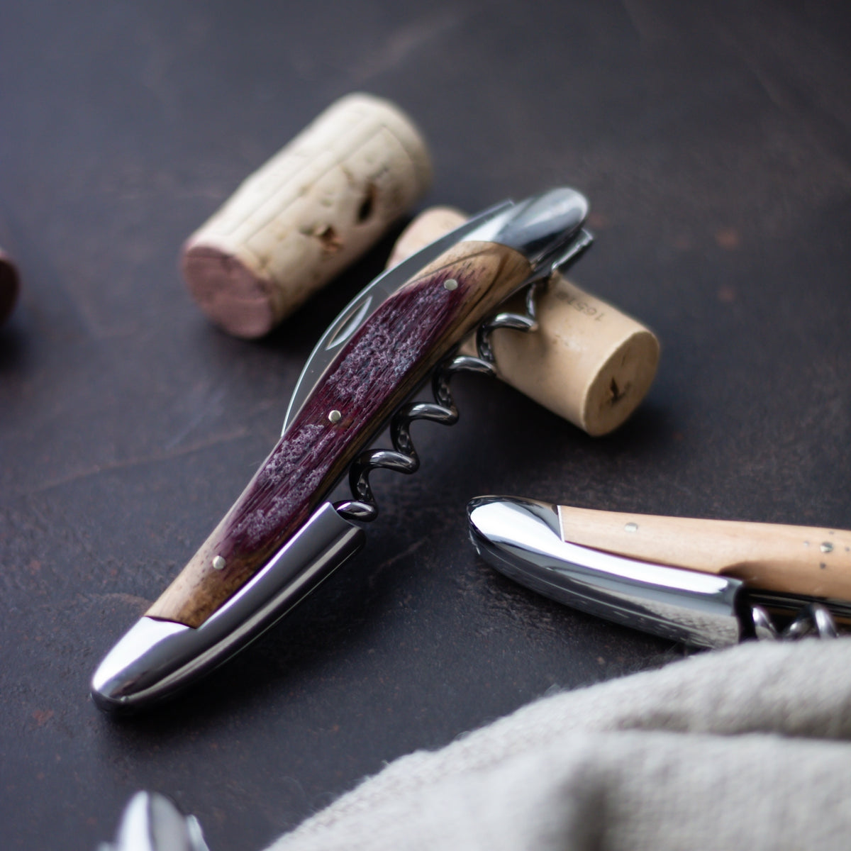 Forge de Laguiole Corkscrew, close-up of wine-stained oak barrel wood handle and shiny steel bolster.