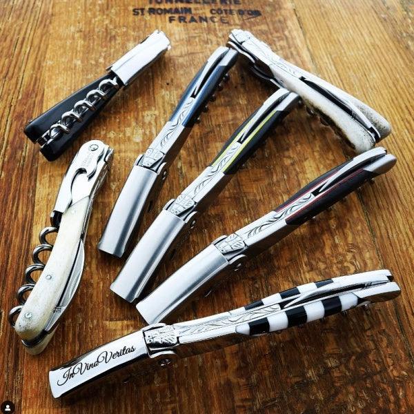 several chateau laguiole style of corkscrew on a wood barrel top